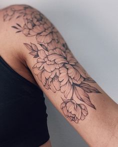 a woman's arm with a flower tattoo on the left side of her arm