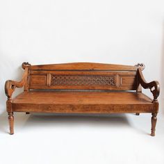 an old wooden bench sitting on top of a white floor next to a light fixture