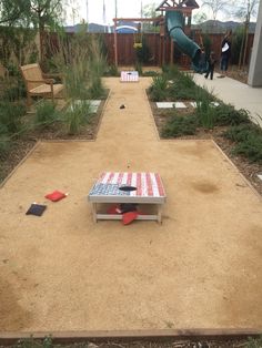 an empty backyard with a picnic table and slide in the back yard, surrounded by grass