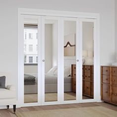 a bedroom with white walls and sliding glass doors that lead to the bed in the room