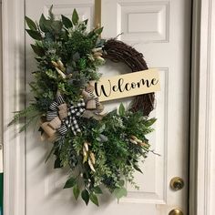 a welcome sign is hanging on the front door with a wreath and ribbon around it