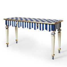 a blue and white striped table with gold trimmings on the legs, in front of a white background