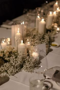 the table is set with candles, flowers and other decorations for a wedding or special event