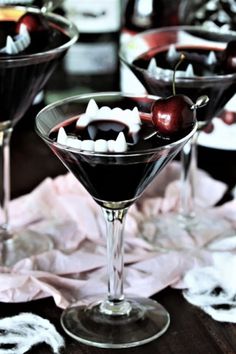 two martinis with cherries and marshmallows in them on a table