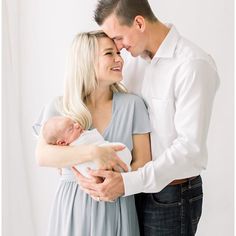 a man and woman holding a baby in their arms