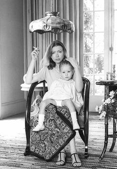 a woman sitting in a chair holding a baby