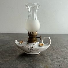 a white vase sitting on top of a table