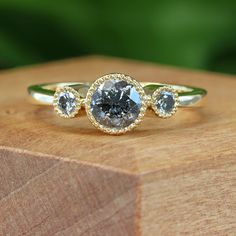 three stone ring sitting on top of a wooden block