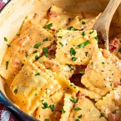 a pot filled with pasta and cheese covered in gravy on top of a checkered table cloth