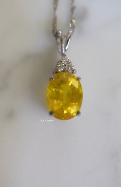 Metal: 14kt White Gold Stone: Yellow Sapphire And Diamond Stone Shapes: Round And Oval-Shape Yellow Sapphire Weight: 3.27 ctw, 9.84 x 7.82 mm Diamond Weight: .08 ctw, round diamonds Measurements Of Pendant From Bail To Bottom Of Pendant: 19.93 mm Weight of entire piece with chain: 2.50 grams Type of Chain: 1.2mm Diamond-cut Singapore Chain Length of Chain: 16 Inches Type of Lock: Spring Ring Note: Other chain styles and lengths available. Pendant can also be sold without chain. Please inquire if Exquisite Oval Brilliant Cut Gemstones, Exquisite Oval Brilliant-cut Gemstones, Luxury Oval Diamond Cut Gemstones, Luxury Yellow Oval Jewelry, Hallmarked Oval Diamond Gemstones, Fine Yellow Sapphire Oval Jewelry, White Gold Oval Gemstones Fine Jewelry, Fine Jewelry Yellow Sapphire Oval, Fine Jewelry Oval Yellow Sapphire