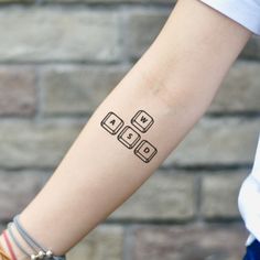 a person with a tattoo on their arm that has four dices in the middle