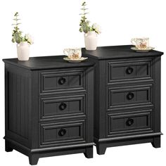 two black dressers side by side with flowers on top and one in the middle