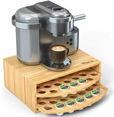 an espresso machine on a wooden stand with coffee cups in front of it