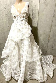 a white wedding dress is displayed on a mannequin