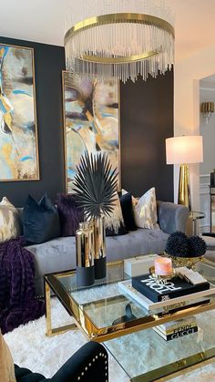 a living room filled with furniture and a chandelier hanging over the top of it