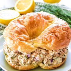 a close up of a bagel on a plate with lemons in the background