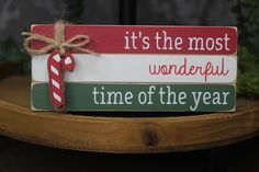 a wooden sign that says it's the most wonderful time of the year with a candy cane