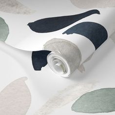 a roll of white and blue wallpaper with green leaves on the side, next to it