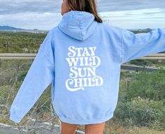 Stay Wild Sun Child - Summer Oversized Retro Hoodie Order 1-2 sizes larger for an oversized fit. Design on front (small) and back (large). This unisex heavy blend hooded sweatshirt is relaxation itself. Made with a thick blend of cotton and polyester, it feels plush, soft and warm, a perfect choice for any cold day. In the front, the spacious kangaroo pocket adds daily practicality while the hood's drawstring is the same color as the base sweater for extra style points. .: 50% cotton, 50% polyes Blue Hoodie Tops For Leisure, Oversized Hoodie For Outdoor Spring Activities, Oversized Hooded Tops For Outdoor, Oversized Tops With Drawstring Hood For Outdoor, Spring Outdoor Hoodie With Letter Print, Oversized Hoodie For Outdoor Spring, Casual Outdoor Hoodie With Letter Print, Casual Hoodie With Letter Print For Outdoor, Casual Letter Print Hoodie For Outdoor