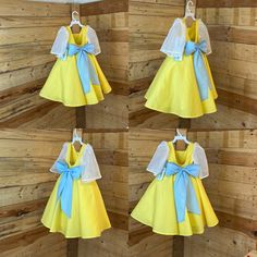 four pictures of dresses hanging on a wall with wooden planks behind them, all in yellow and blue