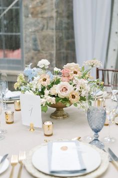 a table set with plates, silverware and flowers