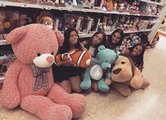 several girls are posing with stuffed animals in a store