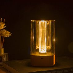 a lamp that is sitting on top of a table next to a vase with flowers