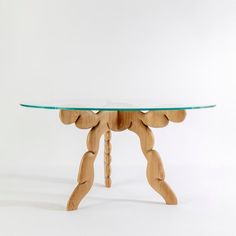 a wooden table with a glass top and legs on one end, against a white background