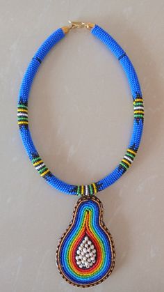 African Pendant Necklace, African Pendant Jewelry, African Beaded Necklace, Zulu Beaded Necklace, Bush Blue Necklace, Gift For HerThis stunning pendant necklace is superbly crafted which makes you stands out in any occasion.Main Color - Bush Blue.Different colors of your choice can be available.Wholesale available at a fair price.For any query please send me a convo or an e-mail.Happy Shopping!!! Traditional Blue Necklaces With Tiny Beads, Traditional Blue Necklace With Tiny Beads, Traditional Blue Beaded Necklaces With Colorful Beads, Blue Beaded Necklace With Colorful Round Beads, Blue Beaded Necklace With Colorful Beads As Gift, Blue Beaded Necklaces With Round Beads As Gift, Unique Blue Beaded Necklace, Traditional Blue Beaded Necklaces, Blue Beaded Necklaces For Gifts