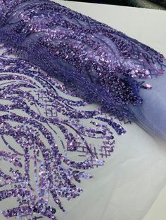 purple sequins are being applied to the fabric