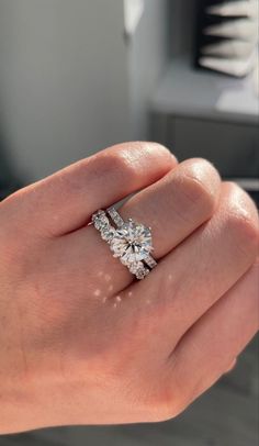 a woman's hand holding an engagement ring