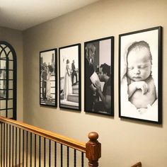 three framed pictures hang on the wall above a banister in a home with stairs and railings