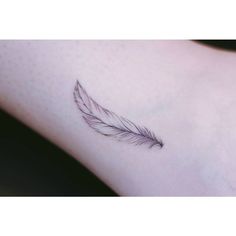 a small feather tattoo on the wrist