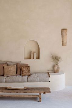 a living room filled with furniture and a wooden coffee table in front of a wall