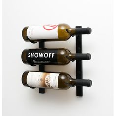 three bottles of wine are hanging on the wall next to each other in a rack