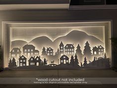 an image of a window with paper cut out of houses and trees in the background