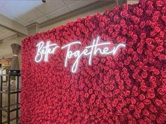 a large red rose wall with the words blt together written in white on it