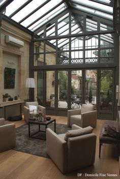 a living room filled with furniture and a large glass roof over the top of it