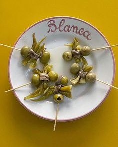 olives are arranged on skewers with the word blanea written on them