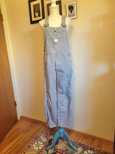 Vintage 1960's authentic Big Mac overalls are white with a vertical blue conductor stripe. Features several multi use pockets are on the front chest, button fly, two front waist pockets, two large back pockets, two pockets on the side of the right leg,  and hammer hook on the left leg. Adjustable overall straps. Union Made. 100% cotton. In excellent condition! These overalls have only slight light brown mark on the right overall strap (see picture). Priced for condition. Size Estimate M (waist 34") Make sure to allow 1"-3" allowance for comfort and movement. White Bib Front Overalls With Pockets, White Utility Overalls With Pockets, Casual Striped Overalls With Pockets, Striped Cotton Overalls, Spring Striped Cotton Overalls, Striped Cotton Overalls For Spring, White Overalls With Pockets For Workwear, Striped Overalls Outfits, Dungarees Outfit