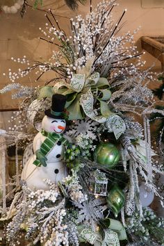 a christmas tree decorated with snowmen and greenery