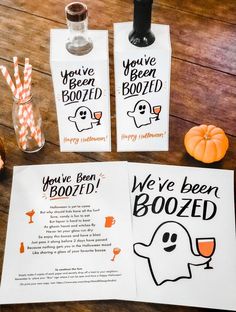 two halloween booze bags and some candy sticks on a table with paper tags that say, you've been boozed