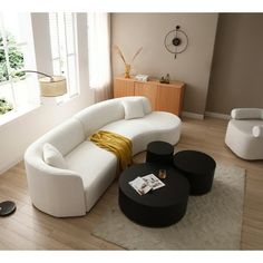 a living room filled with furniture and a large window in the corner on top of a hard wood floor