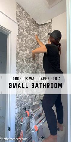 a woman painting the wall in her bathroom with text overlay that reads gorgeous wallpaper for a small bathroom