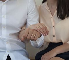 two people holding hands while sitting next to each other