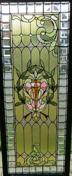 a stained glass window sitting on top of a wooden bench in front of a building