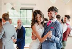 a bride and groom dance together at their wedding reception in front of other guests on the dance floor