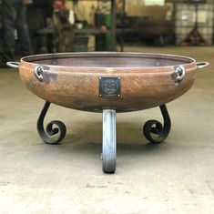 a large metal bowl sitting on top of a dolly in a warehouse or workshop area