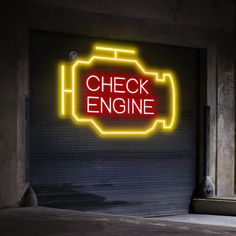 a neon sign that reads check engine on the side of a garage door