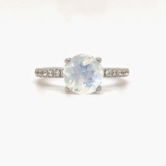 M A T E R I A L S ~ Solid Sterling Silver ~ Gold Vermeil & Rose Gold Vermeil (Heavy Plating over Sterling Silver) S T O N E S Cruelty Free ~ Genuine Moonstone ~Flawless/Colorless Simulated Diamond ~ Center Stone : 2.00ct ~ 1/2 Eternity Band Stones: 0.16ct TOTAL: 2.25 ctw D I M E N S I O N S ~ Band: 1.75mm ~ Setting: 8.0mm Height 7.5mm Width R I N G C A R E ~ Simple instructions to care for the ring is not expose your jewelry to chemicals like bleach, chlorine, hairspray, to avoid chemical re White Multi-stone Moonstone Ring, White Moonstone Ring With Si Clarity, White Oval Celestial Rings, White Oval Celestial Ring, White Multi-stone Moonstone Ring Fine Jewelry, White Moonstone Celestial Ring, Celestial Style White Opal Ring, White Moonstone Ring With Si Clarity For Gift, White Gemstones For Anniversary In Fine Jewelry Style